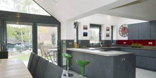 A modern kitchen with green bar stools